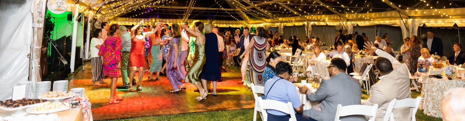 People dancing under a clear-top tent 