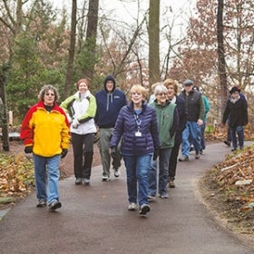 a group of 9 adults on a walking tour in Morris Arboretum