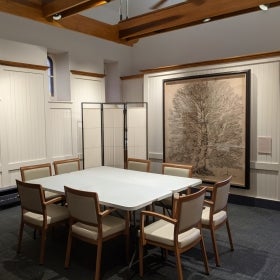 A white and wood board room with a conference table and chairs.