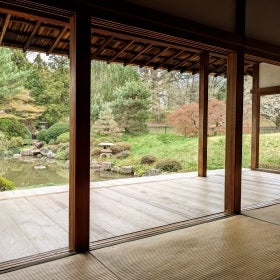 A Japanese style room overlooking a pong and garden.