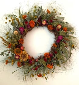 A fall wreath decorated with dried flowers.