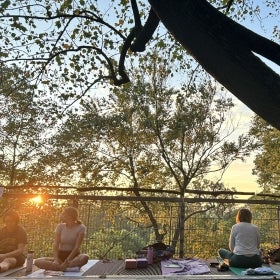 Two woman sitting after outdoor yoga at sunset.