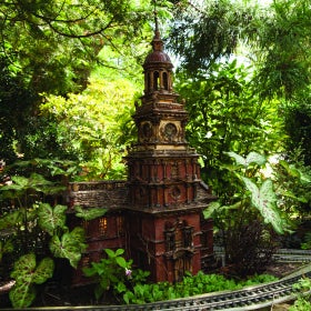 A miniature replica of Philadelphia's Independence Hall set within an outdoor model train display. 