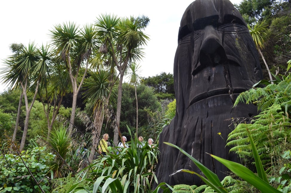 Greenery and people in the background, with a New Zealand sculpture in the foreground. 