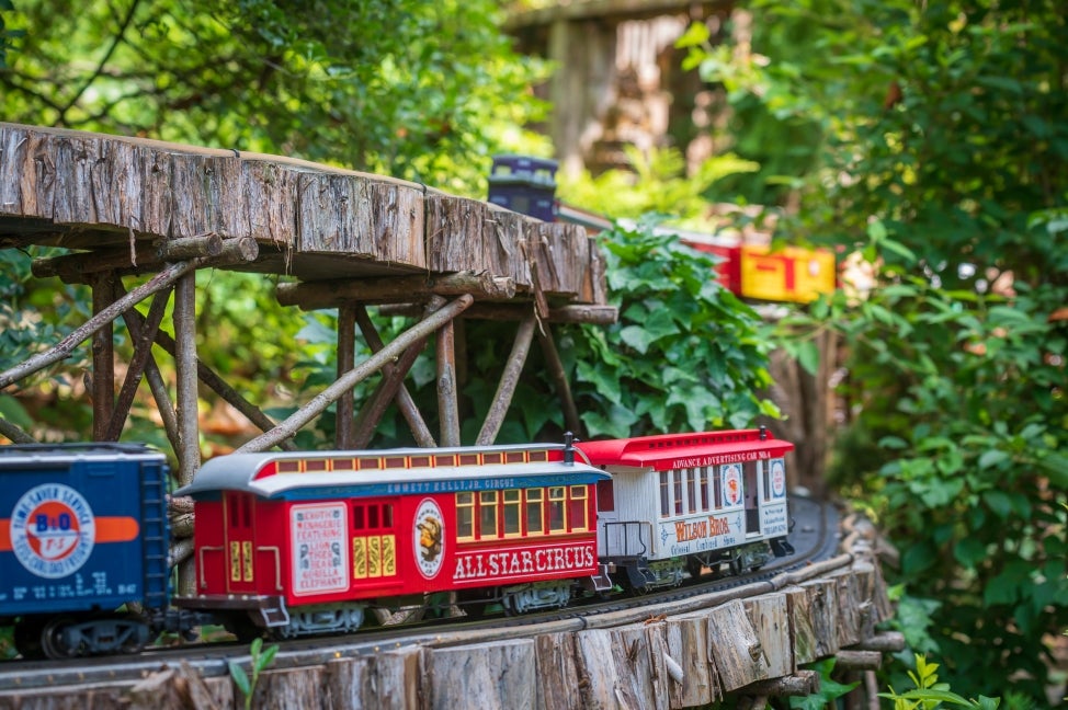 A miniature circus train rides on an outdoor track.