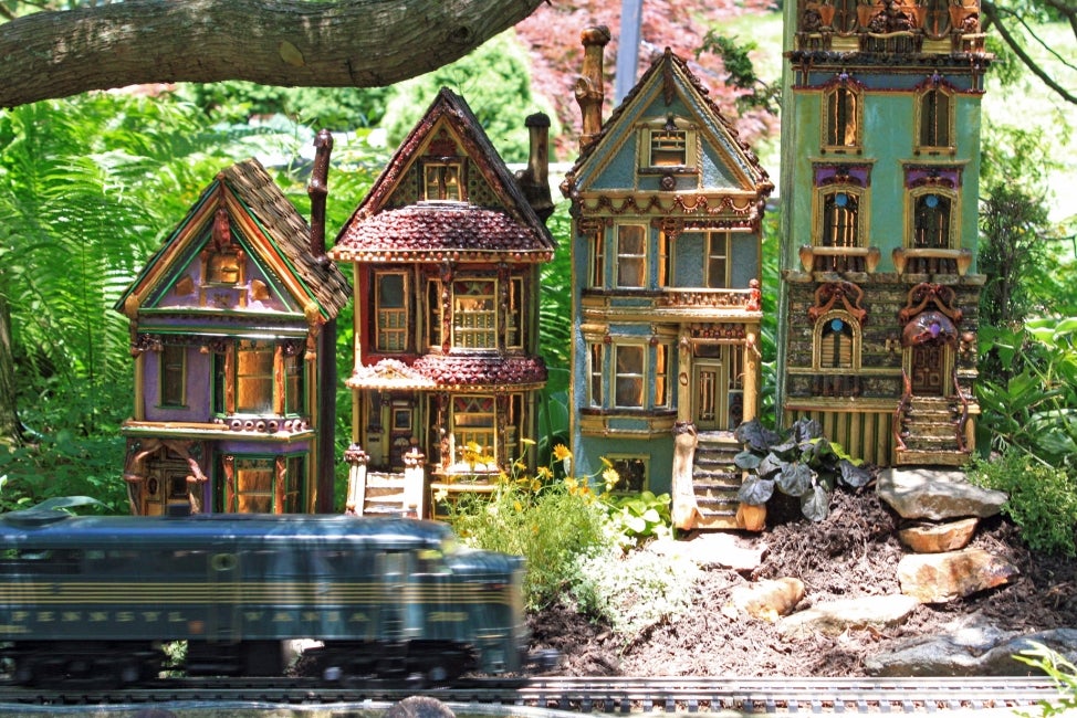 Miniature painted ladies in a model train display.
