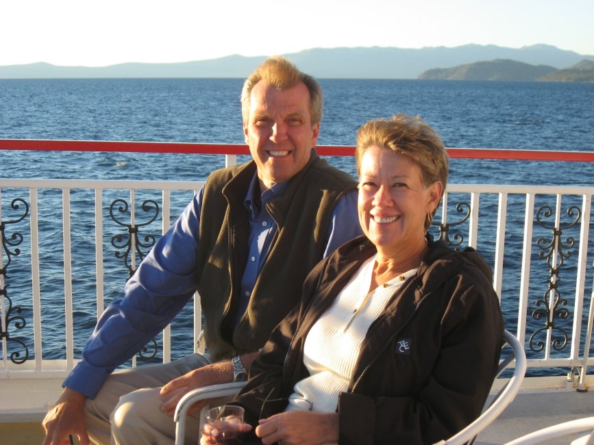 A man and woman smile on a boat. 