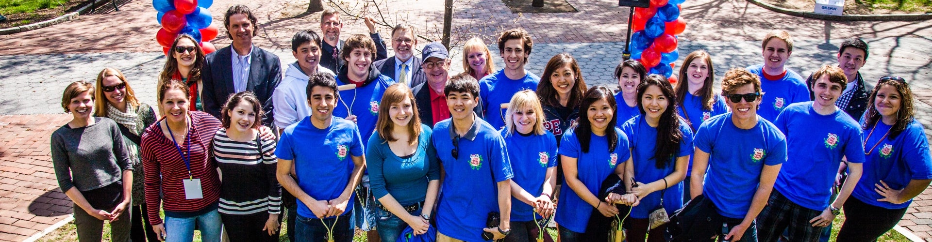 A large group of University of Pennsylvania students smiling and wearing blue t-shirts. 