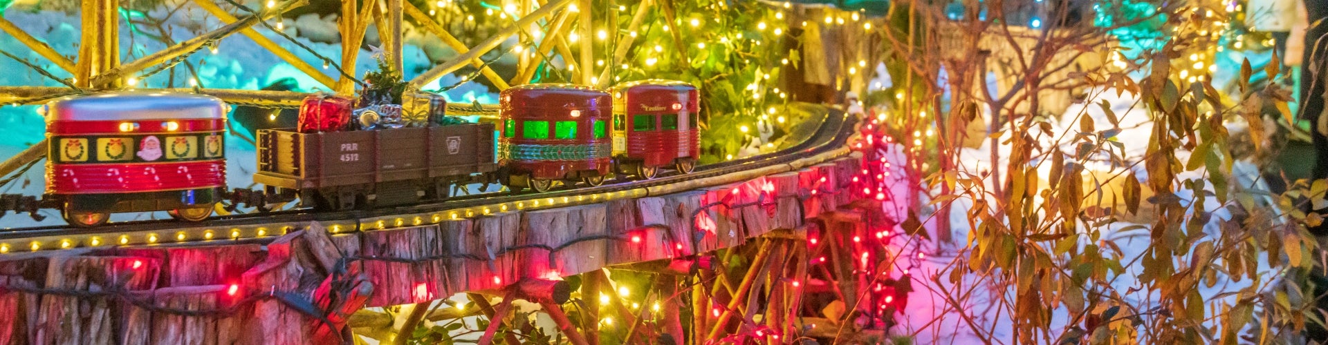 A miniature train display decorated for Christmas.