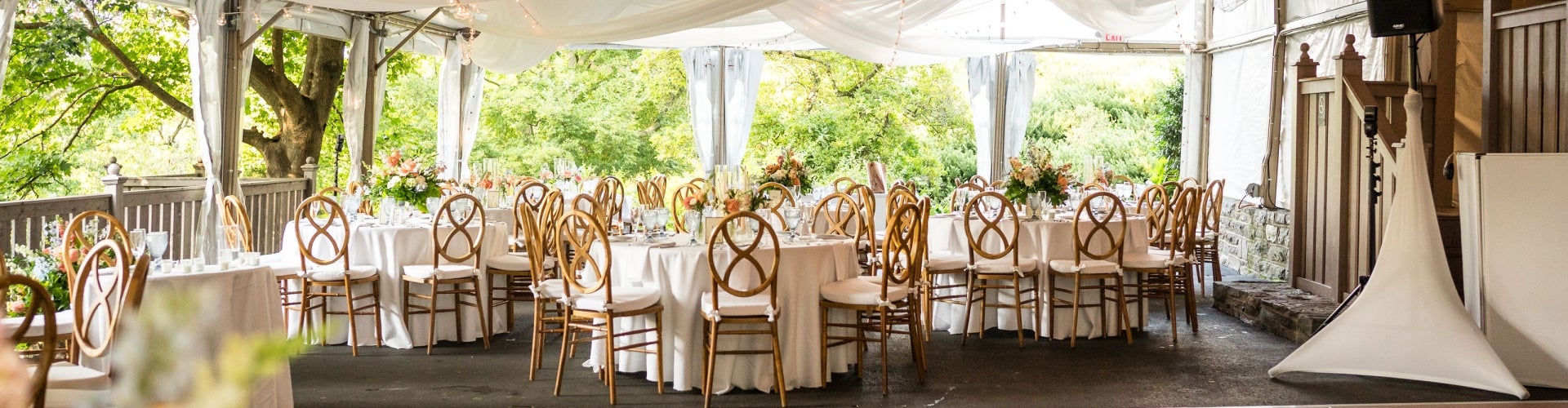 An events space filled with decorated round tables and chairs.