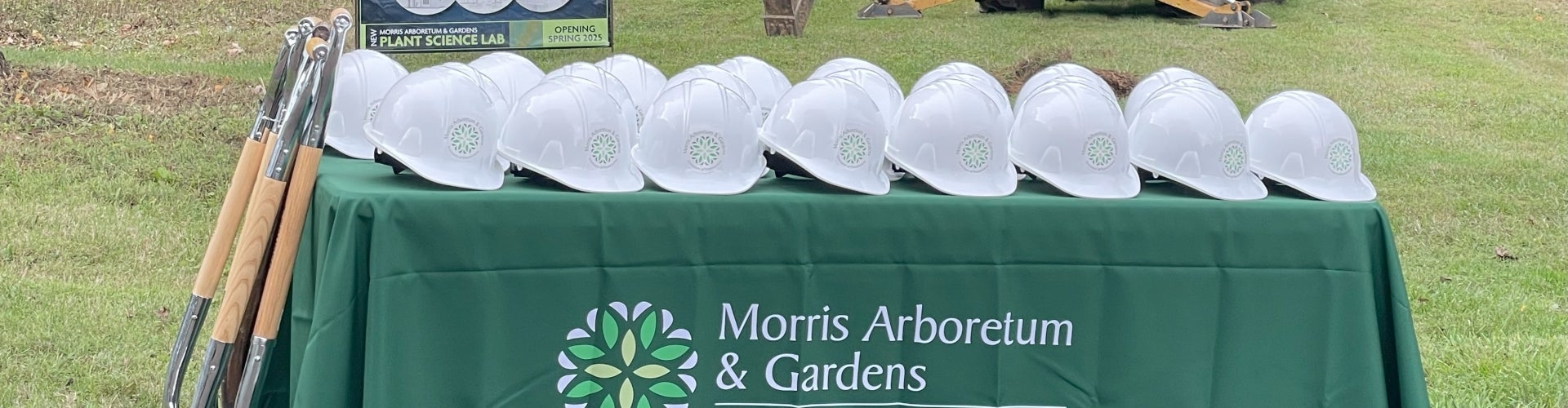 White hardhats with Morris logo on a green tablecloth