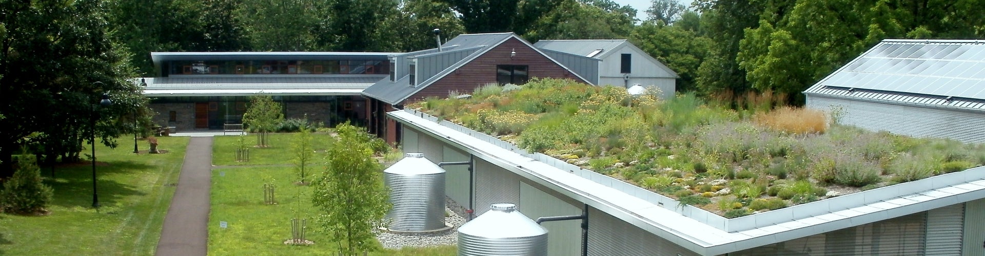 An aerial view of two buildings, with a rooftop greenspace on the one in foreground 