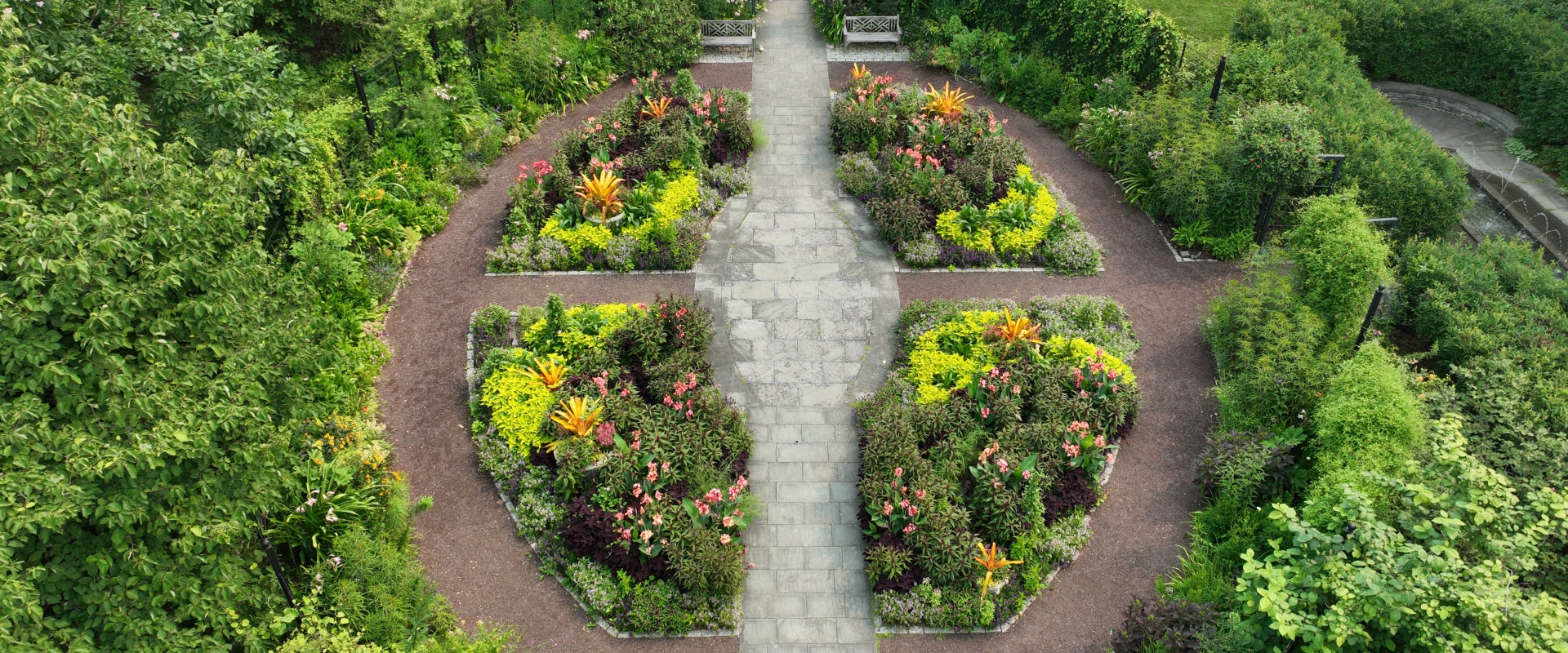 An aerial view of a garden divided into four beds to create an oval with paths running through.  