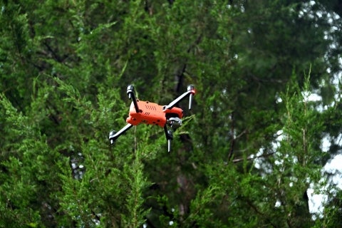 A red drone in the tree tops. 