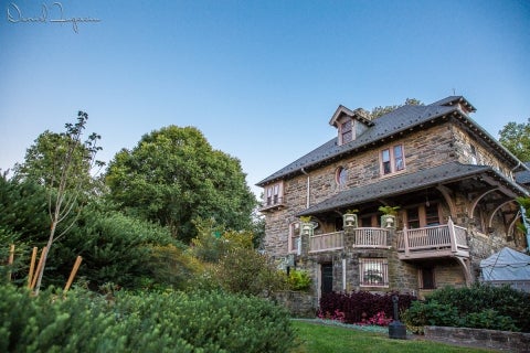 A large stone building surrounded by greenery.