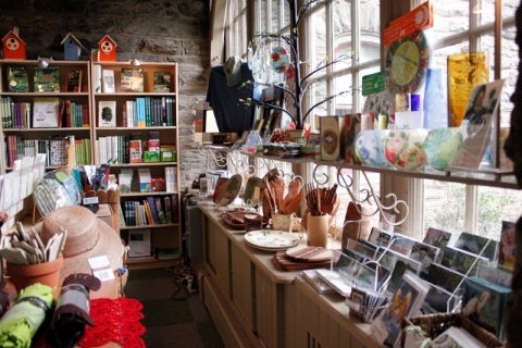 A view of an Arboretum gift shop with shelves filled with postcards, hats, books, and more. 