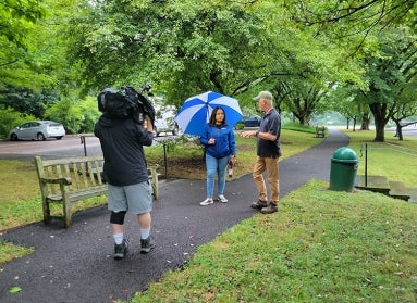 a man talking to a woman in front of a camera