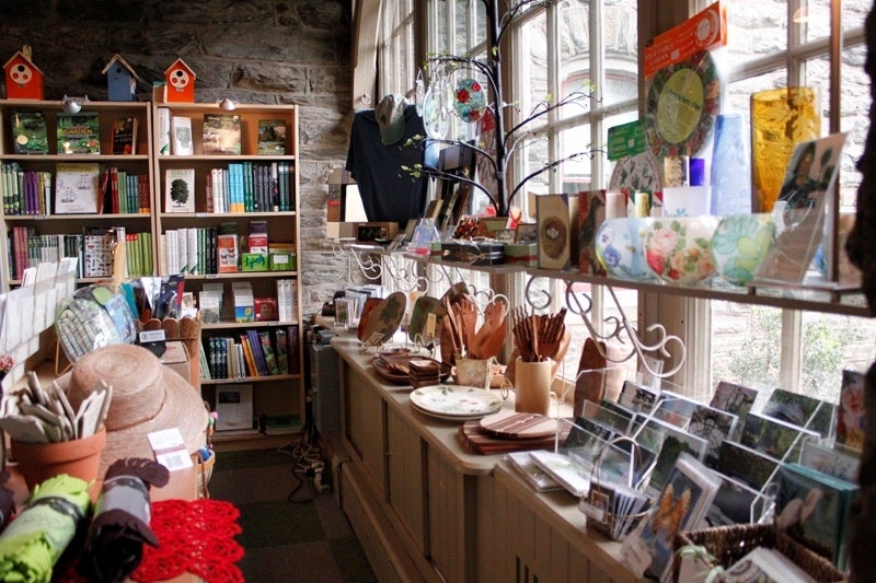 A view of an Arboretum gift shop with shelves filled with postcards, hats, books, and more.