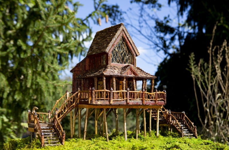 A miniature treehouse made out of natural materials.