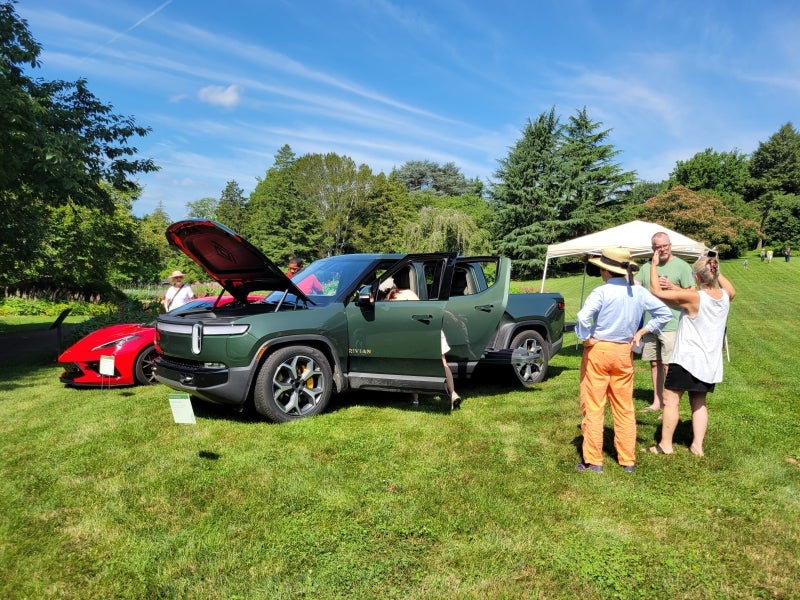 A forest green 2023 Rivian R1T with its hood up