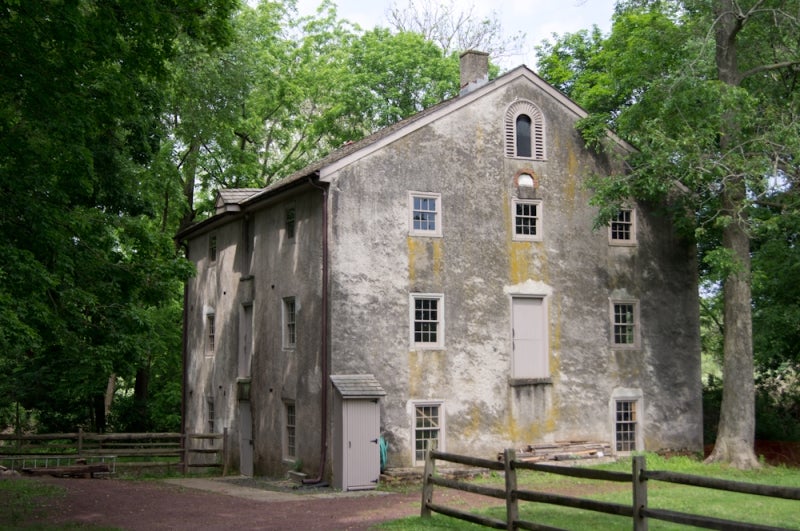 Large gray stone building with fence in front